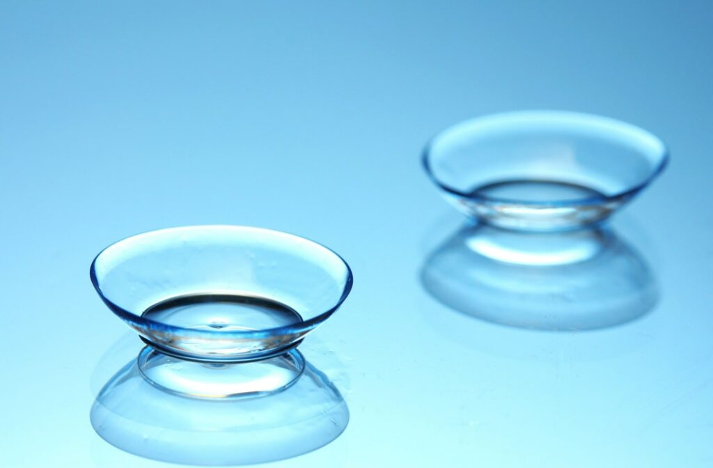 A pair of contact lenses on a blue reflective surface.